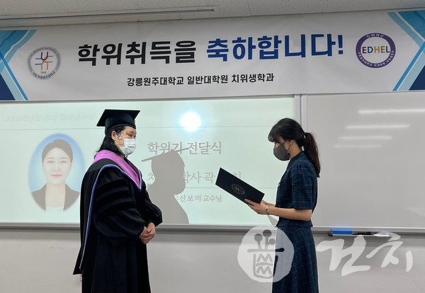 신보미 지도교수가 곽선희씨에게 박사학위를 수여하고 있다.